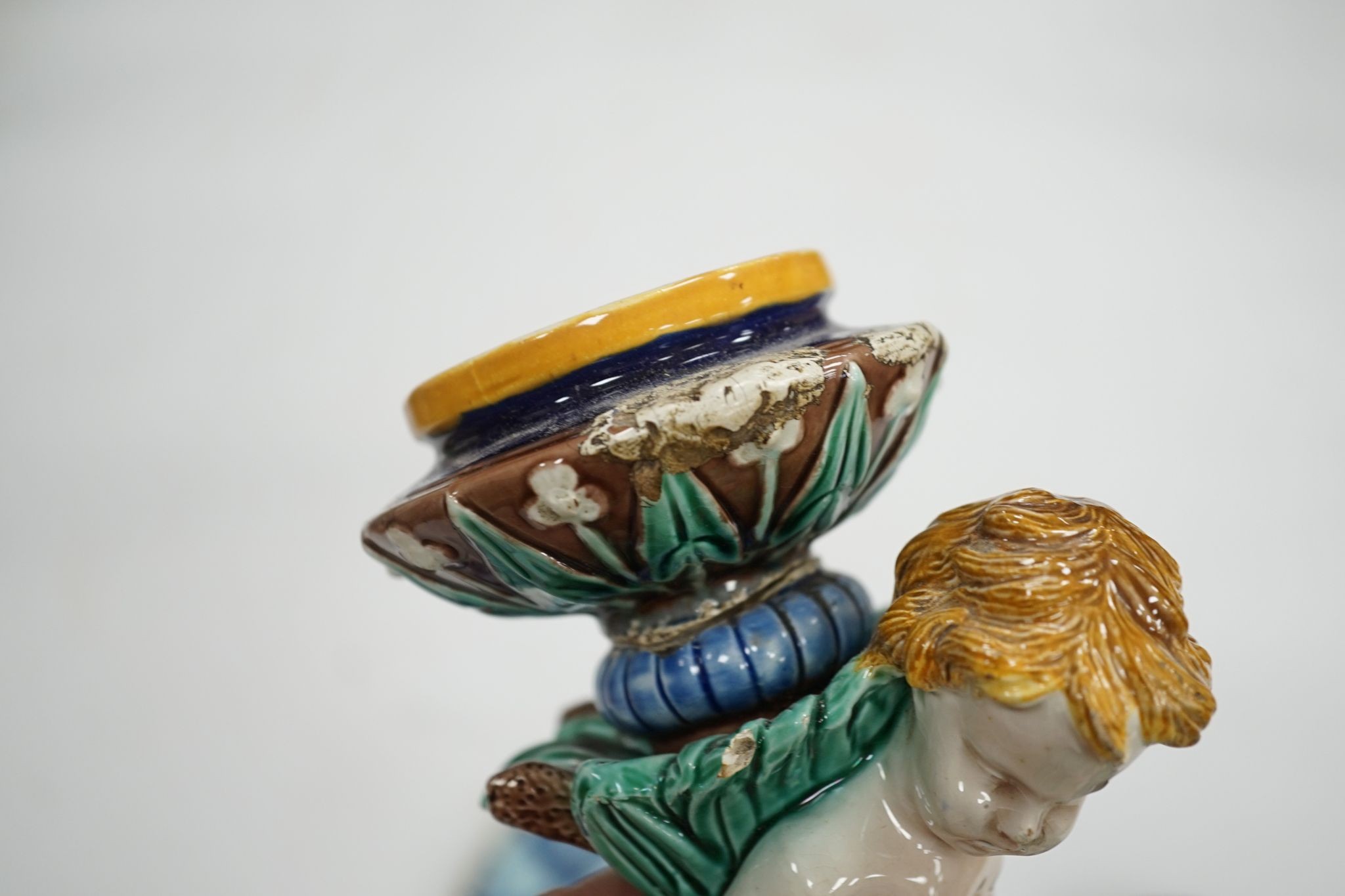 A group of 18th century delftware plates, Wedgwood majolica candlestand (a.f.) and two Victorian framed pot lids